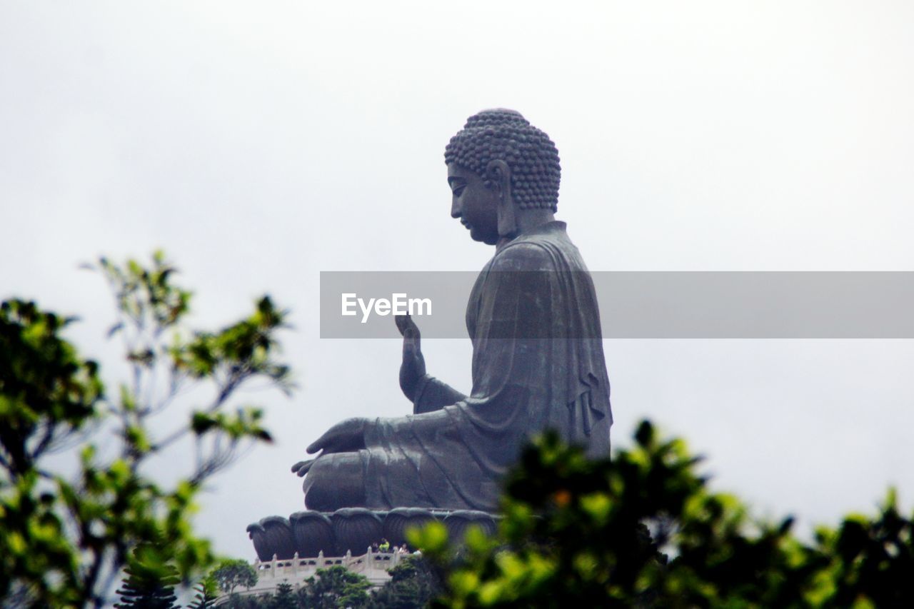 Low angle view of tian tan buddha against sky