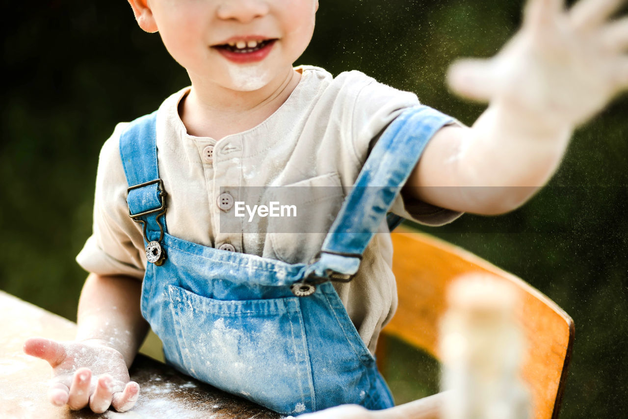 Portrait of boy preparing food in yard