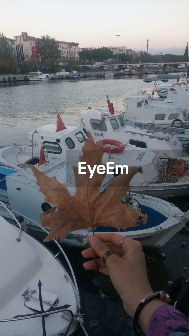 PERSON HOLDING UMBRELLA IN CITY BY RIVER