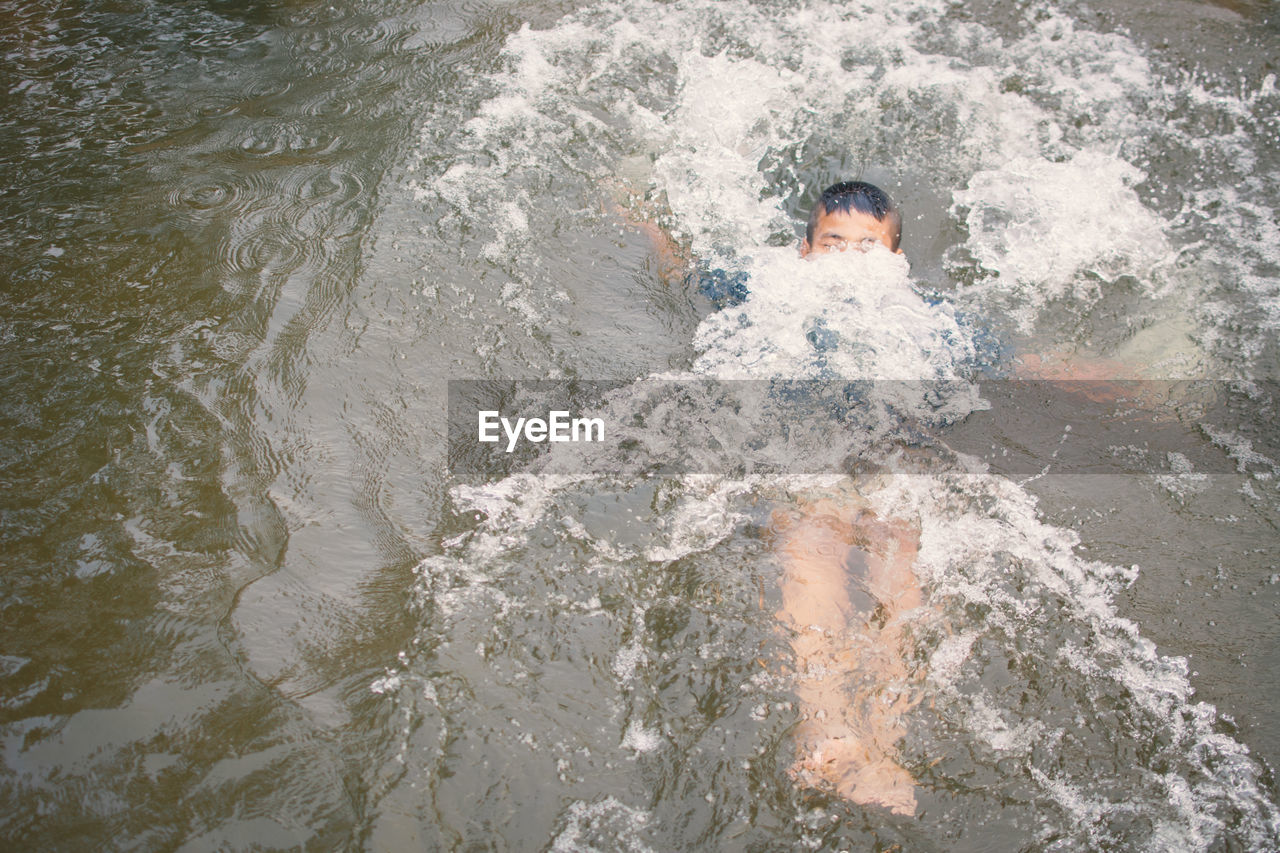 Boy swimming in lake