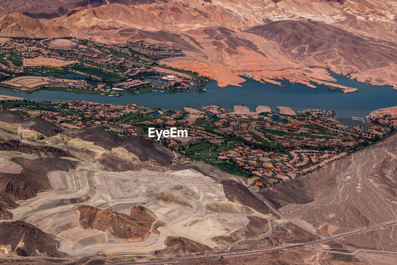 High angle view of houses and mountains by river