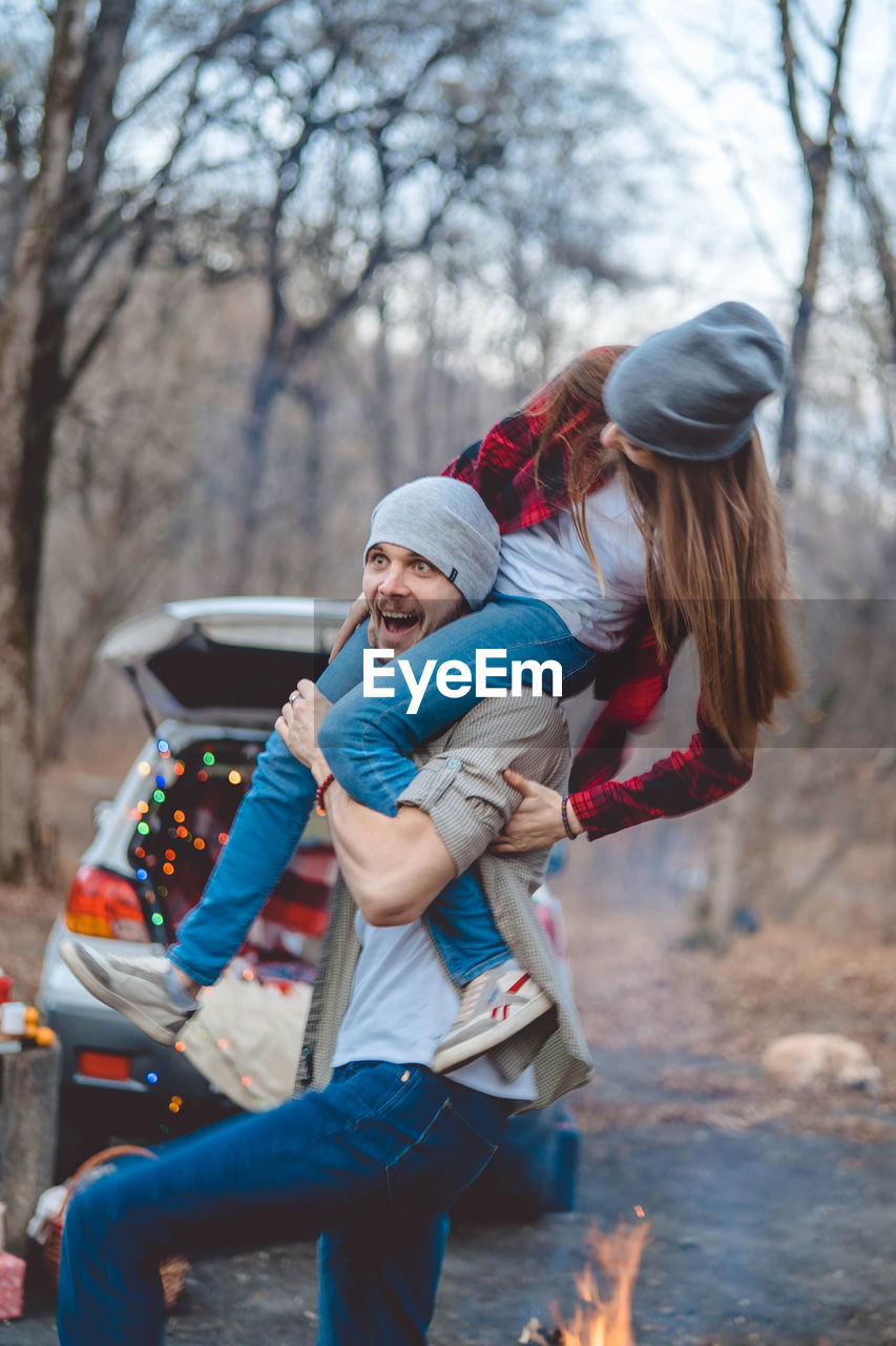 REAR VIEW OF MOTHER AND SON ON TREE