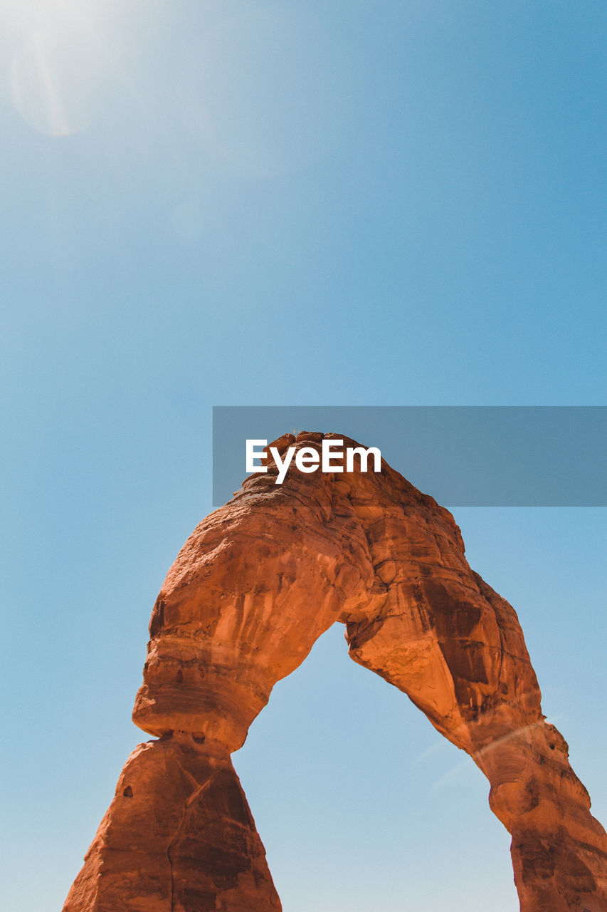 View of natural arch against clear sky during sunny day