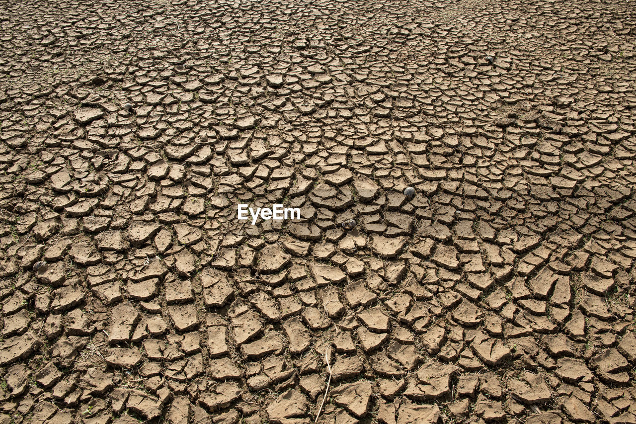 drought, cracked, soil, climate, dry, arid climate, environment, backgrounds, scenics - nature, pattern, barren, full frame, nature, textured, land, landscape, no people, extreme terrain, road surface, environmental issues, desert, field, high angle view, dirt, day, asphalt, climate change, outdoors, mud, brown, accidents and disasters