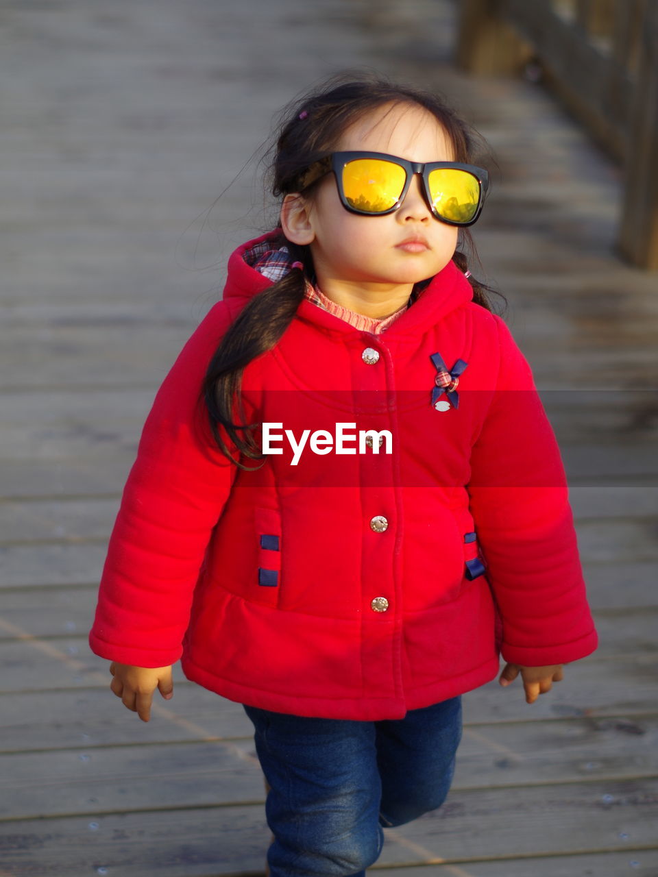 Portrait of young girl wearing sunglasses walking 