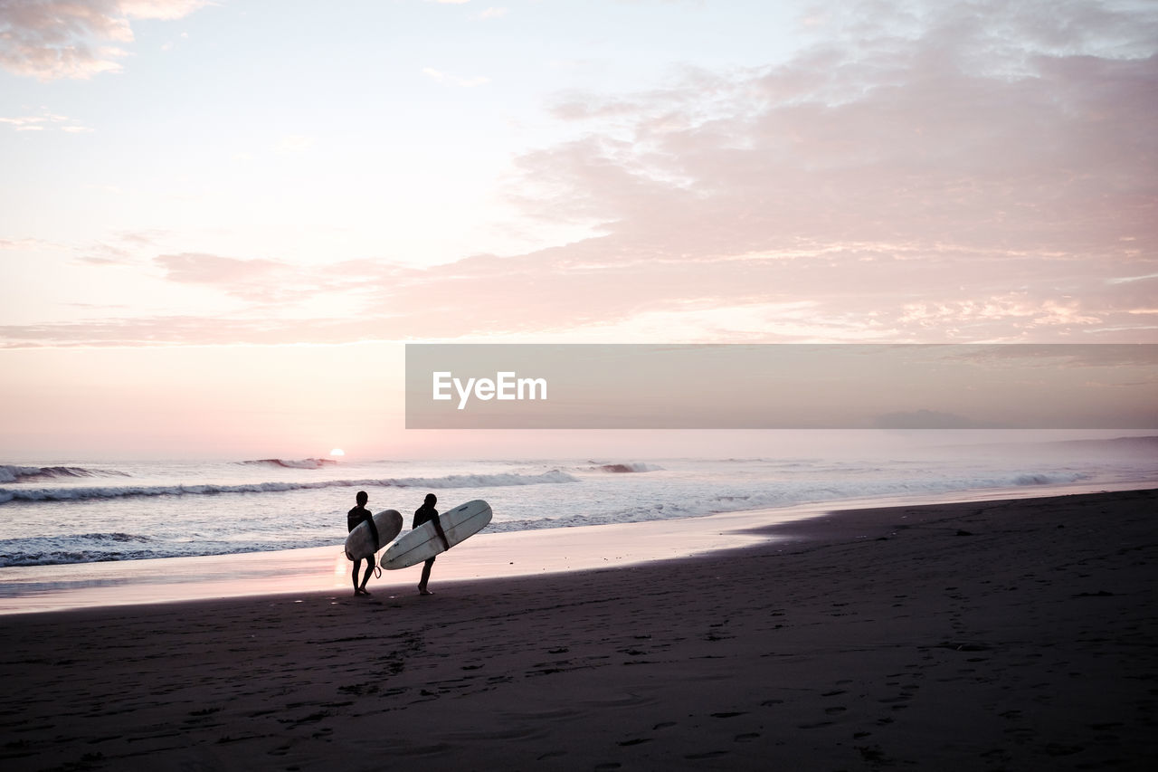 TWO PEOPLE ON BEACH AGAINST SKY