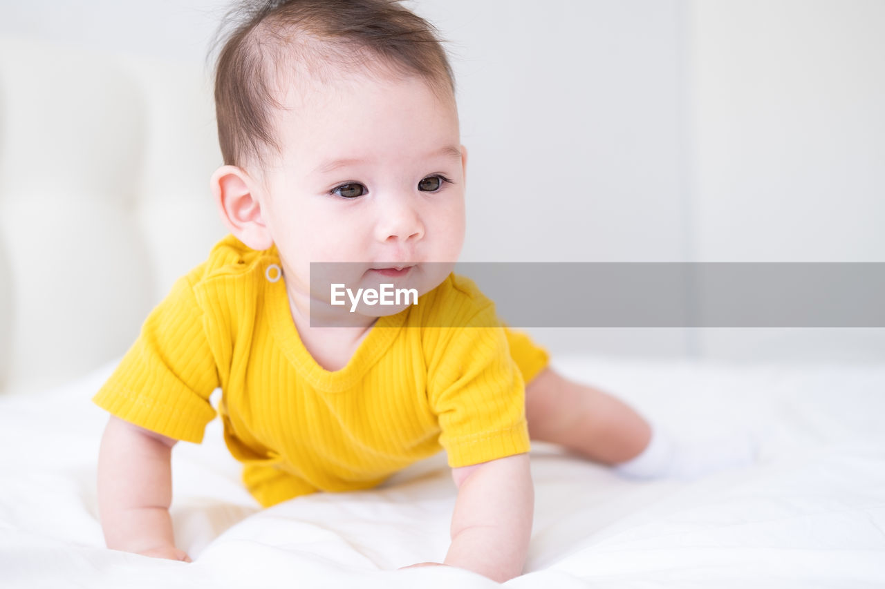 portrait of cute baby boy sleeping on bed at home