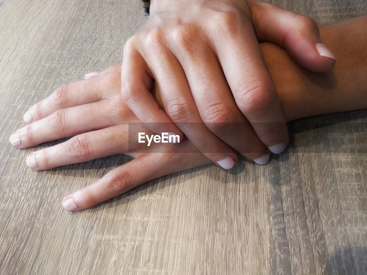 Cropped hands of woman on wooden table