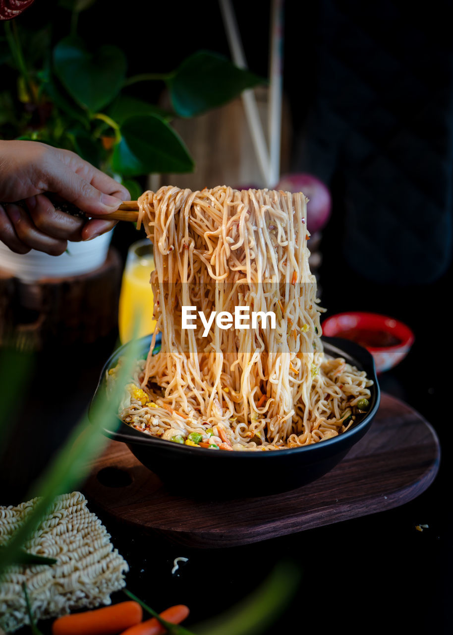 Cropped hand of person preparing food on table