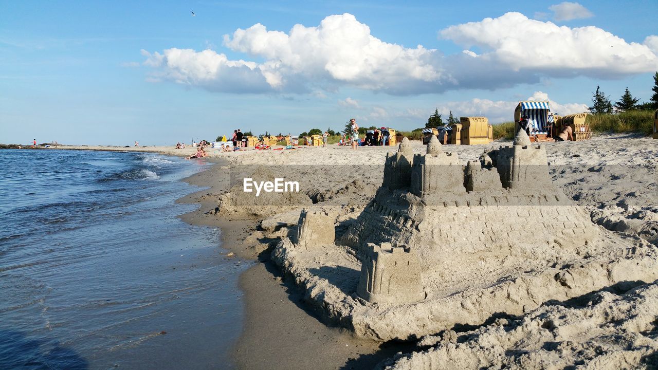 PANORAMIC VIEW OF PEOPLE AT BEACH AGAINST SKY