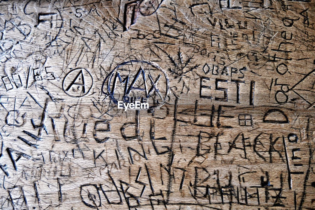 Close-up of text penned into wooden bench