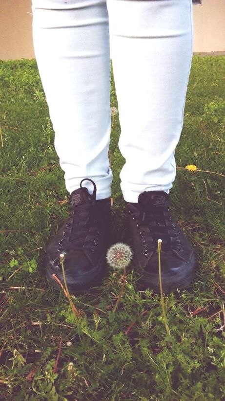 LOW SECTION OF WOMAN STANDING ON GRASSY FIELD