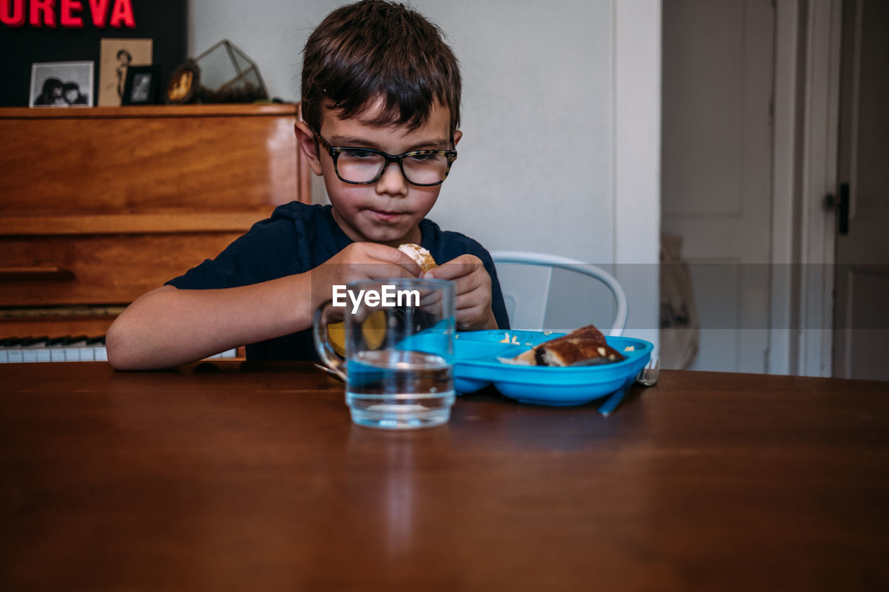 Young boy slowly eating a meal at the kitchen table