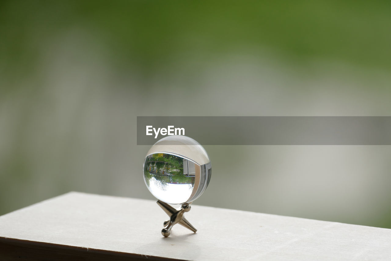 CLOSE-UP OF CRYSTAL BALL ON WHITE TABLE