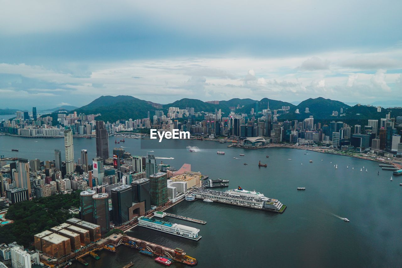 HIGH ANGLE VIEW OF HARBOR AND BUILDINGS AGAINST SKY