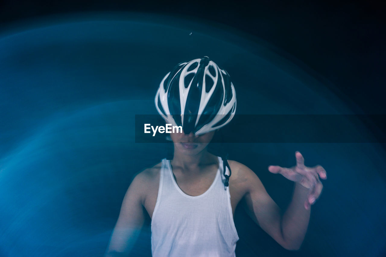 Woman wearing helmet against colored background