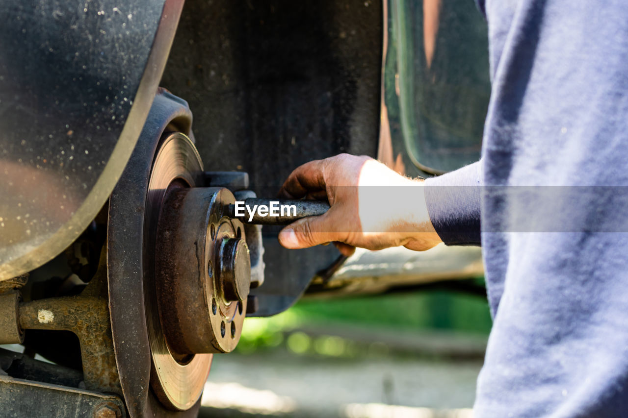 CLOSE-UP OF MAN WORKING ON MACHINE