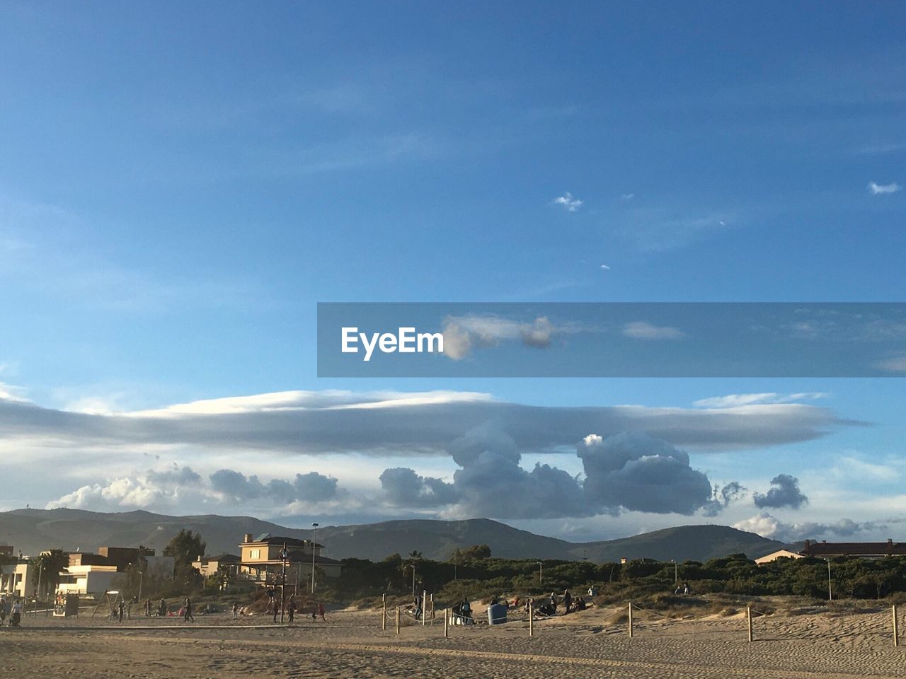 Beach and mountain range against blue sky