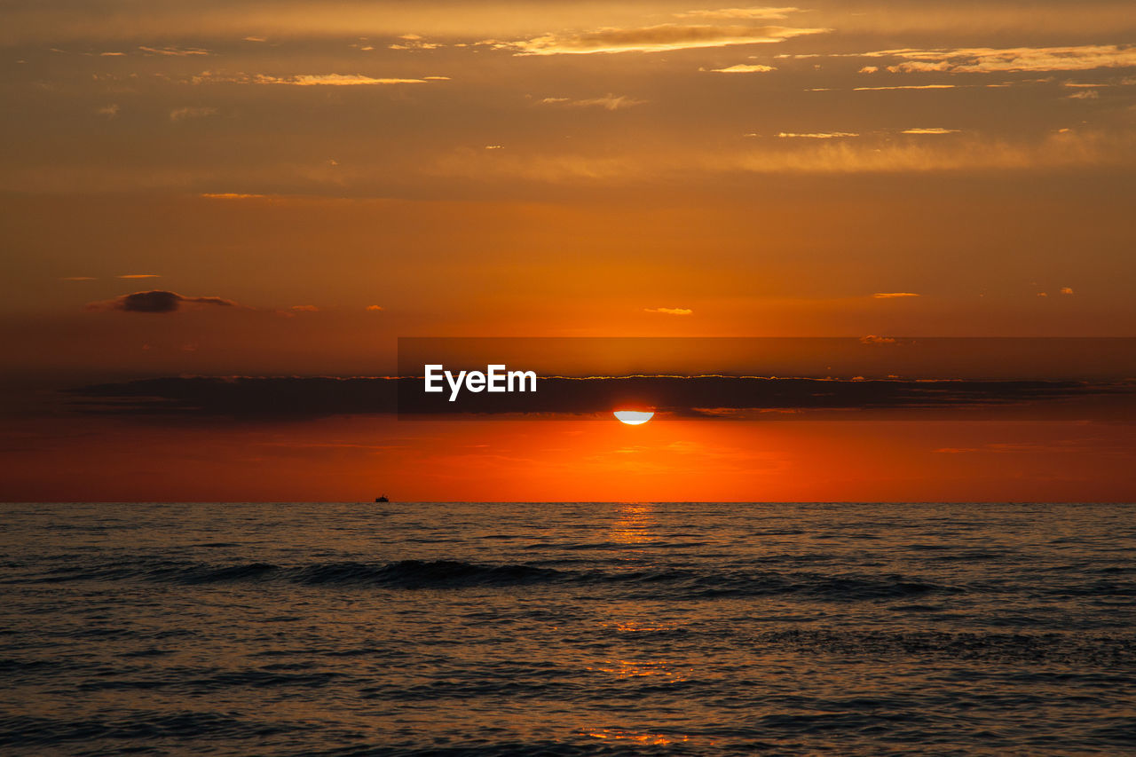 Scenic view of sea against romantic sky at sunset