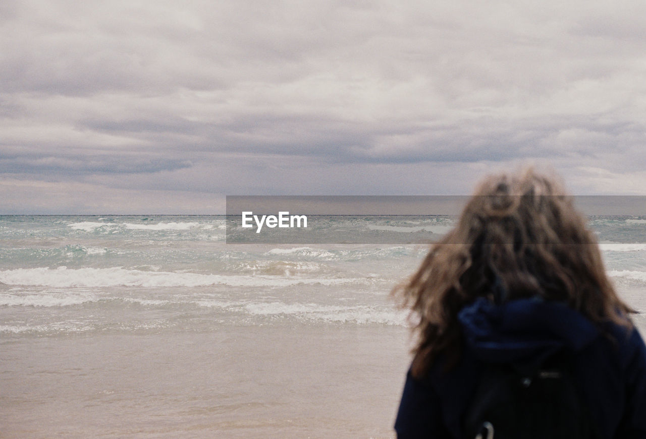 Rear view of woman looking at sea against sky