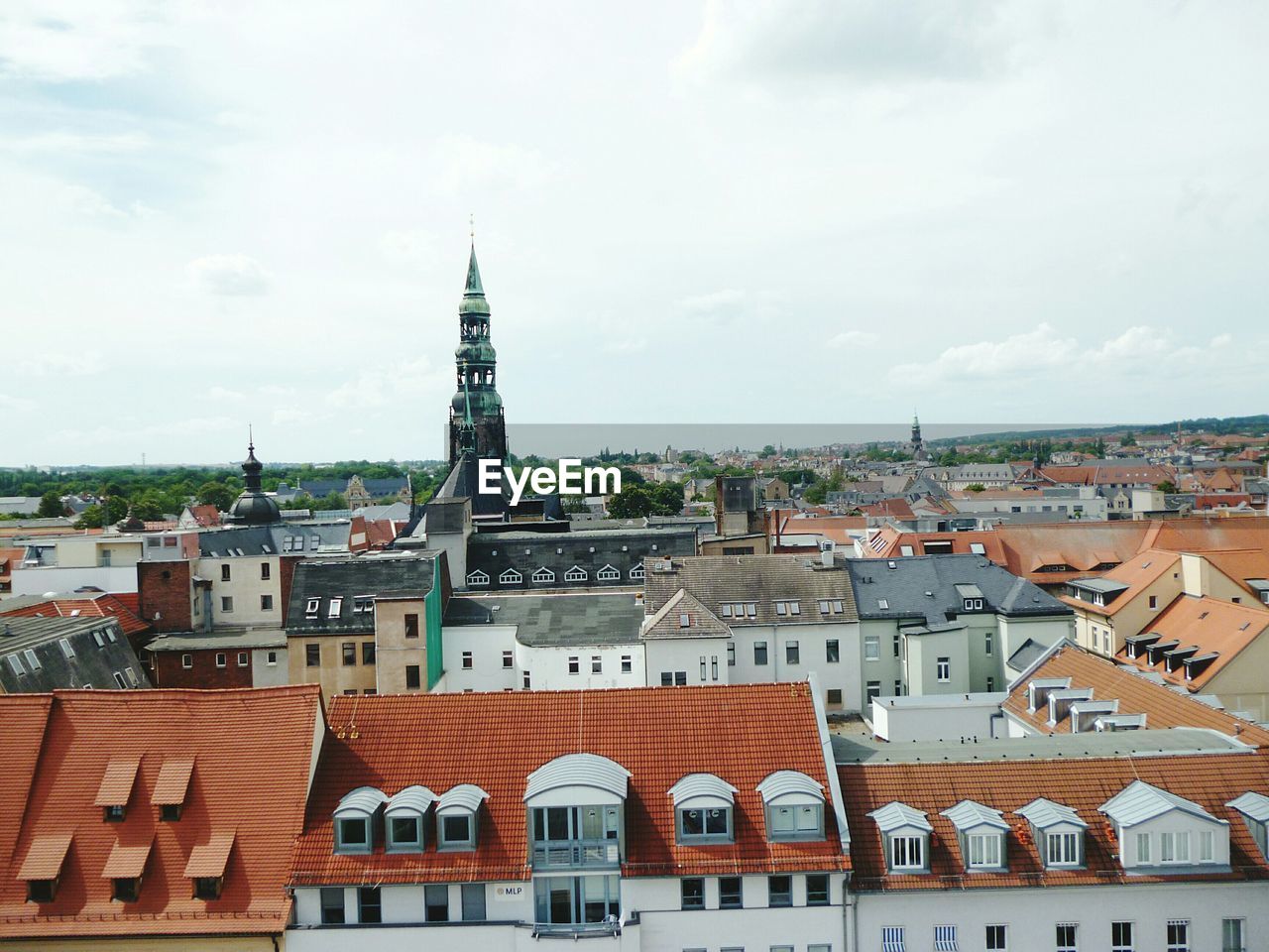 View of cityscape against cloudy sky