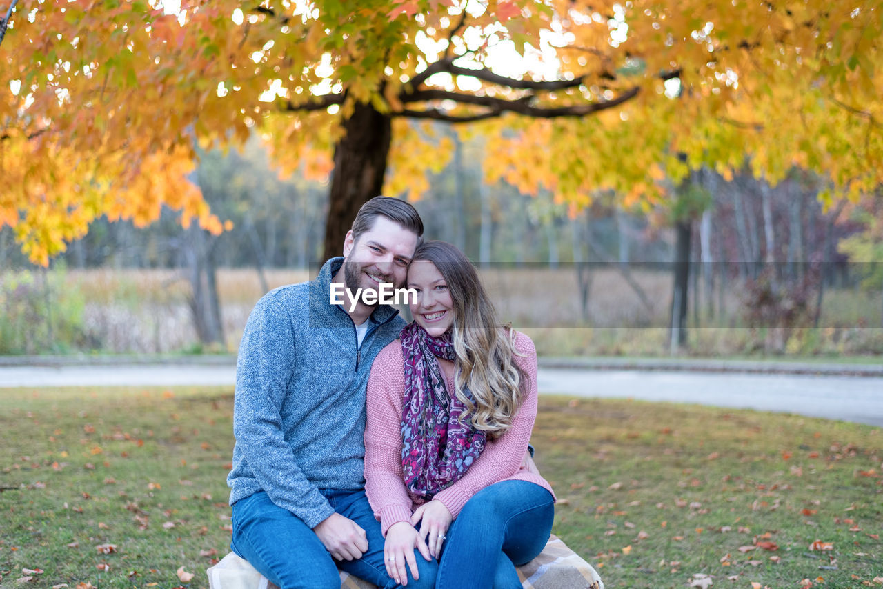 PORTRAIT OF A SMILING YOUNG WOMAN IN AUTUMN