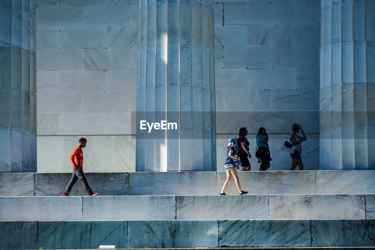 PEOPLE WALKING BY MODERN BUILDING