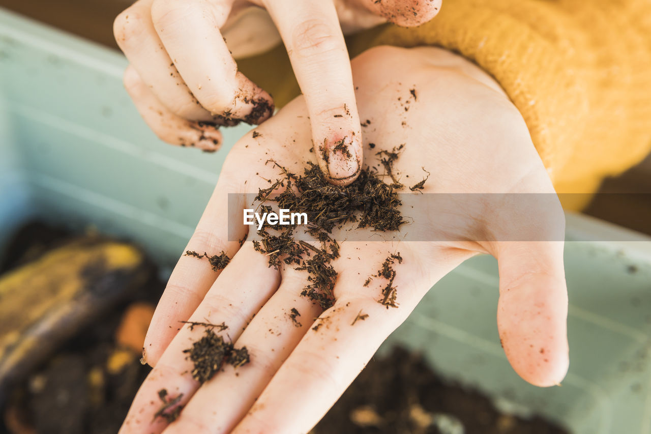 Woman pointing at worm with dirt on hand