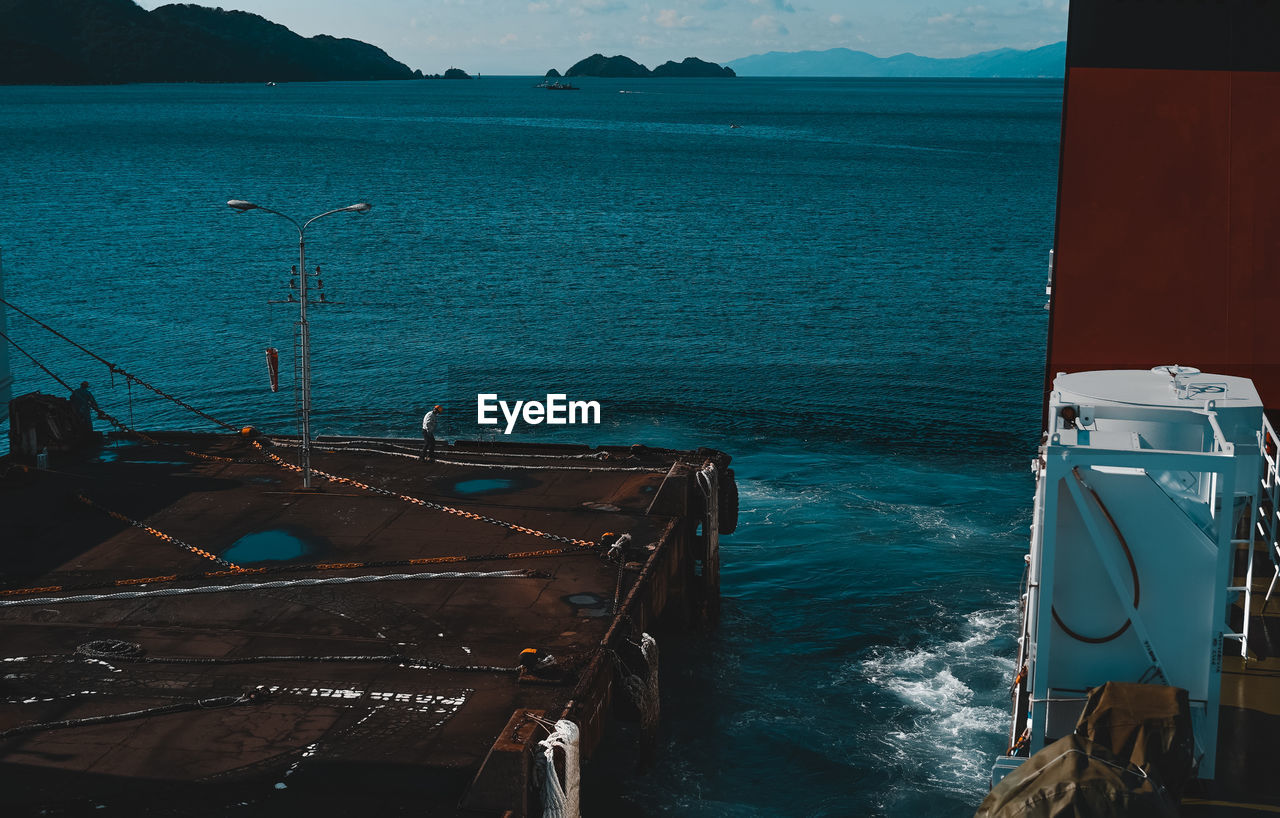 HIGH ANGLE VIEW OF SEA BY MOUNTAIN AGAINST SKY