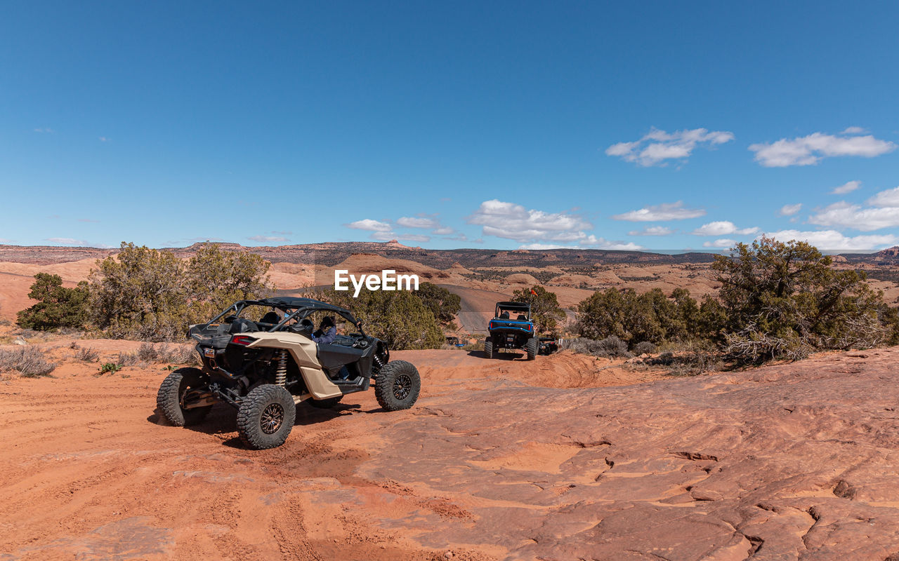 Full frame view of tourists enjoying a 4x4 tour in rugged terrain on a beautiful sunny day