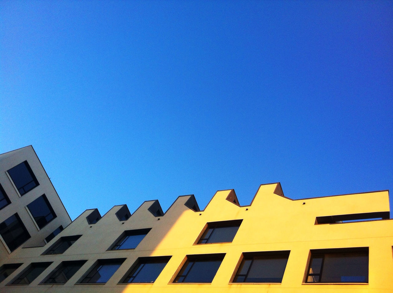 LOW ANGLE VIEW OF BUILDING AGAINST BLUE SKY