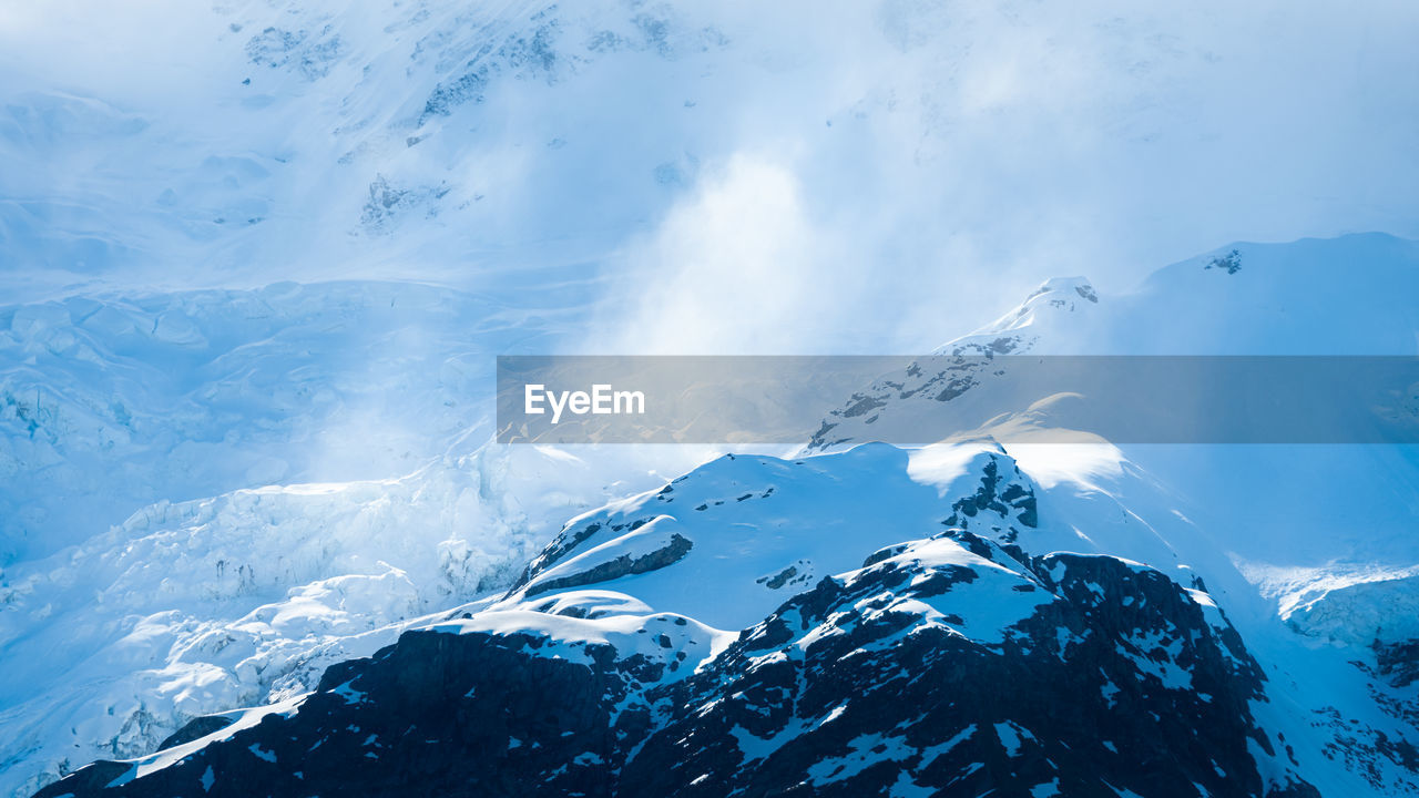 Aerial view of snowcapped mountains against sky