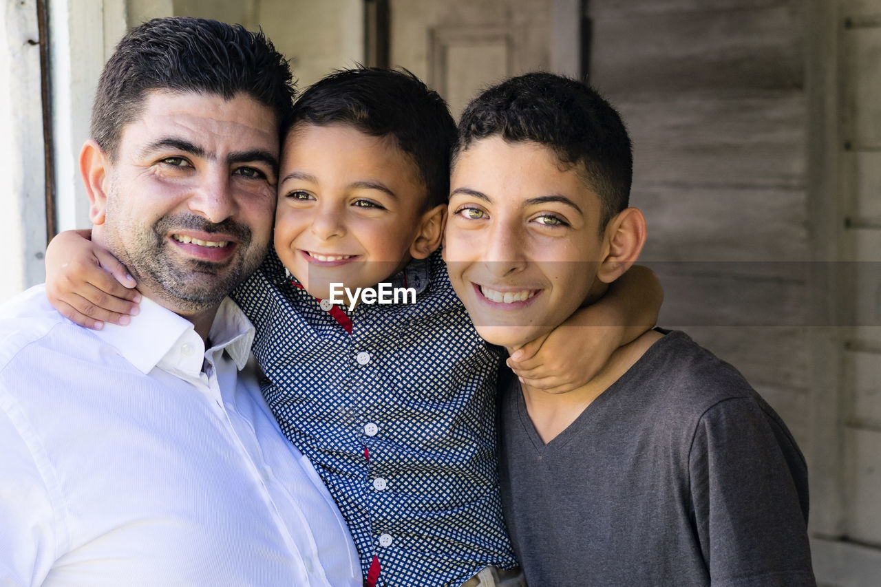 Portrait of happy brothers with father