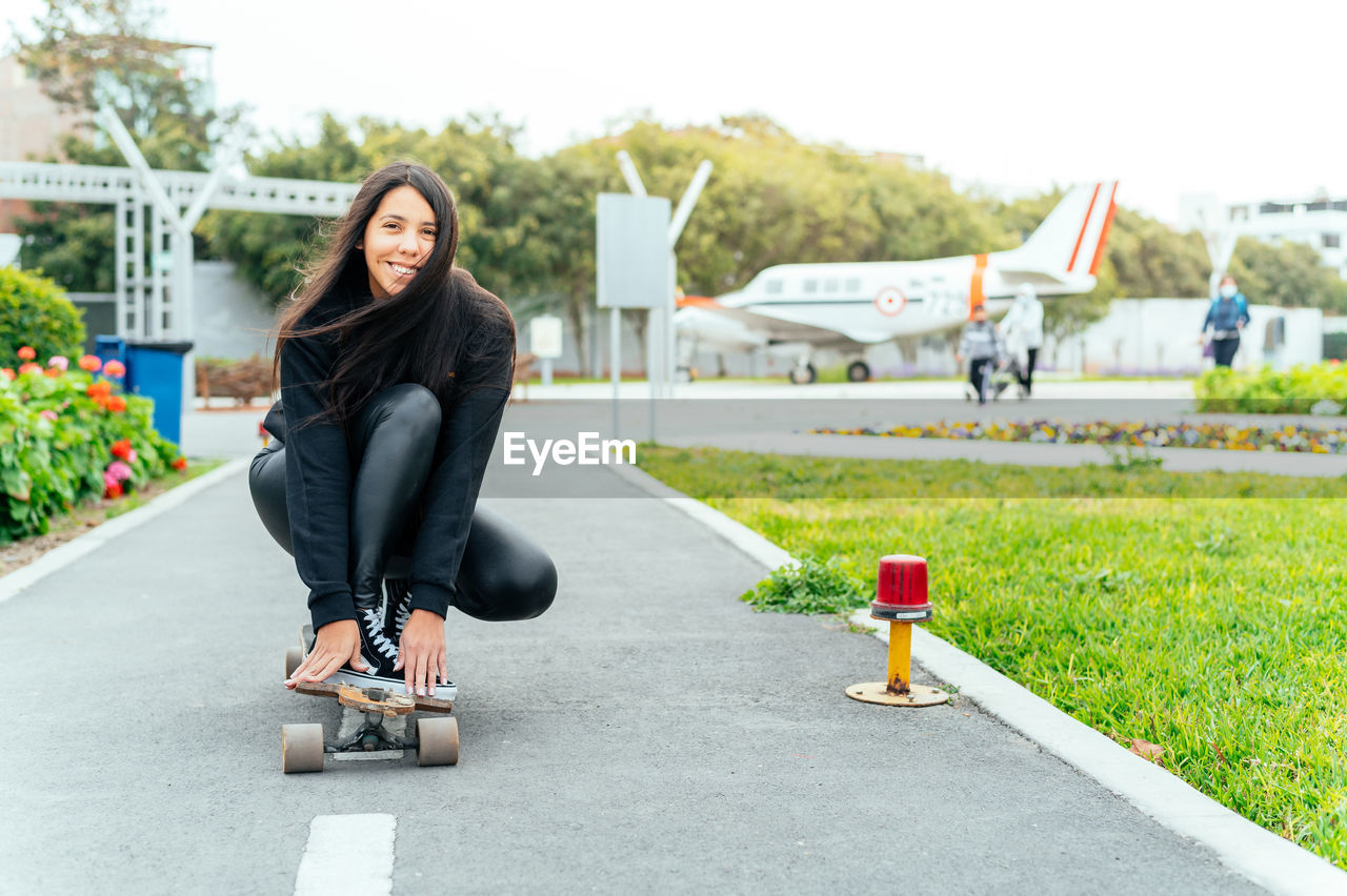 portrait of young woman standing on road