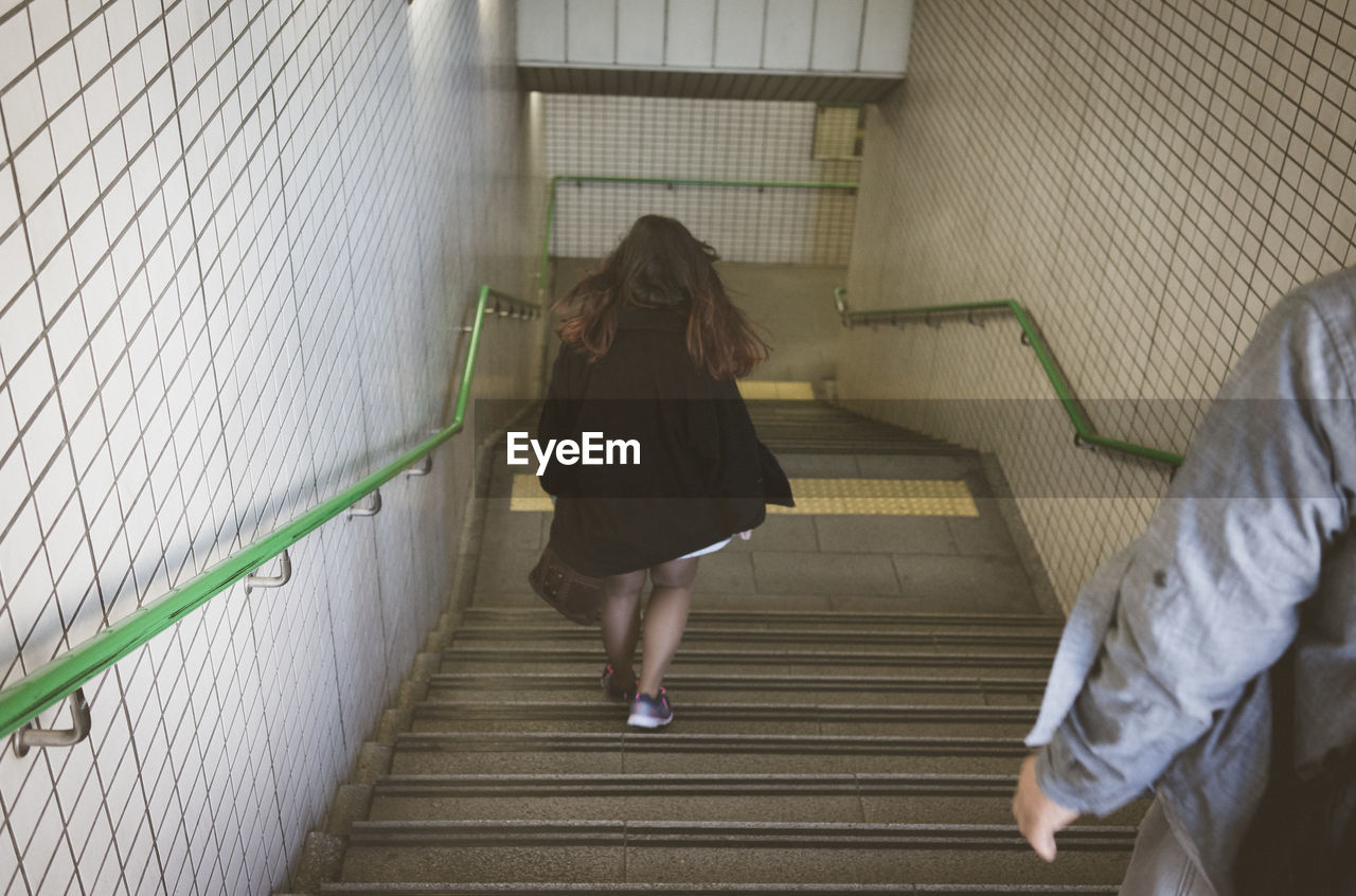 Rear view of woman walking on staircase