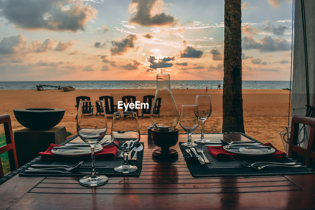 Place setting on table against beach