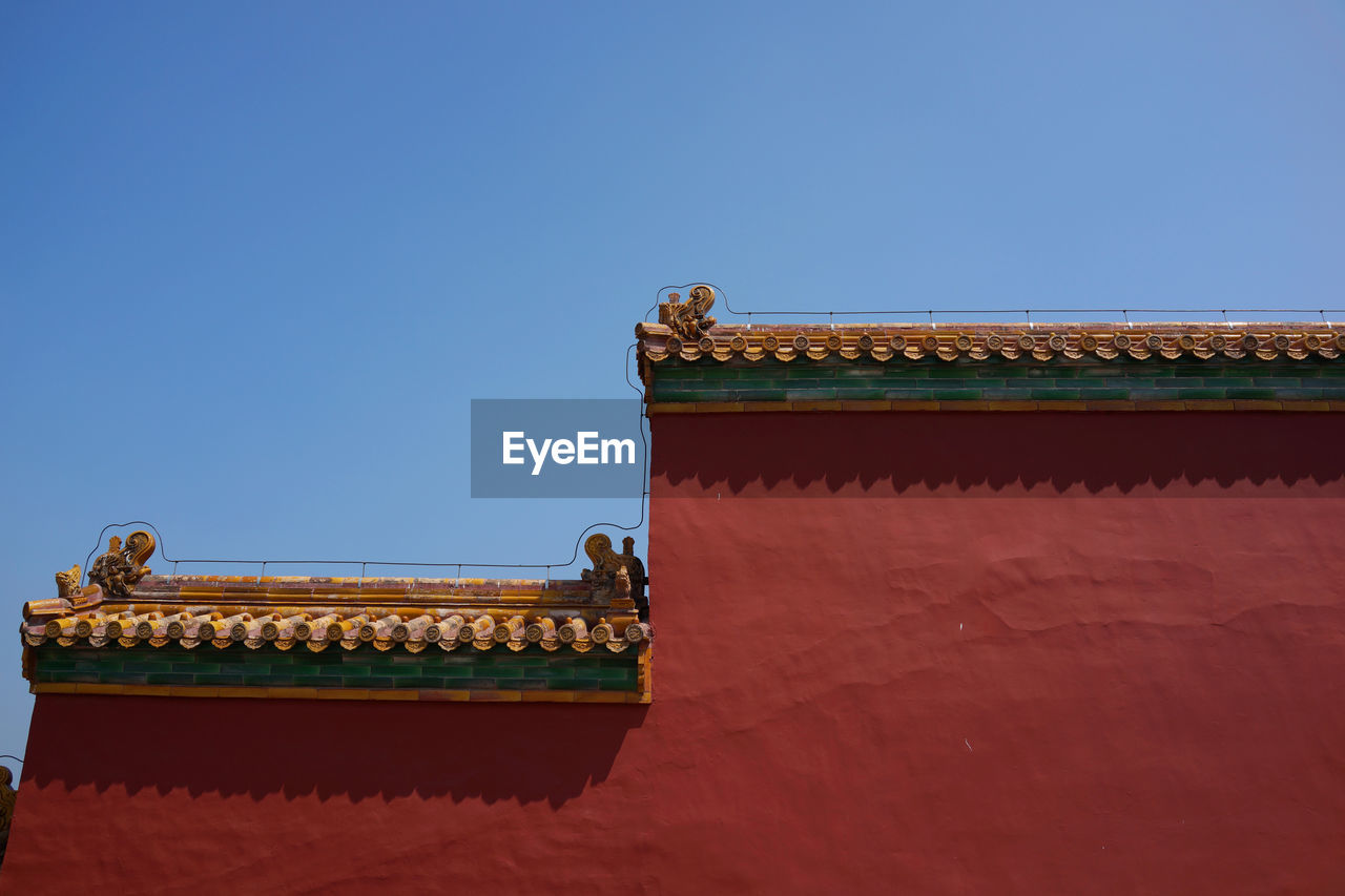 Low angle view of architectural wall against clear sky