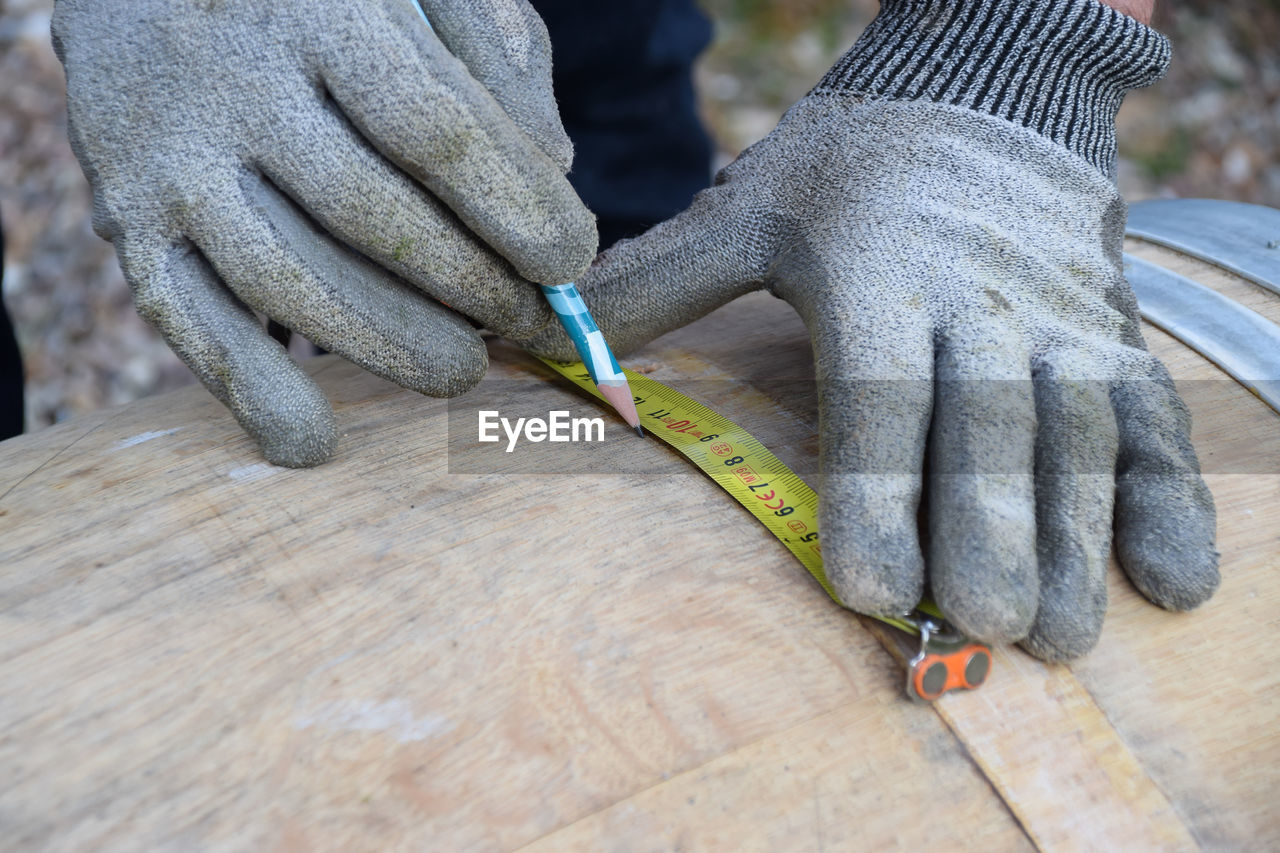 Cropped image of worker working on wood with tools