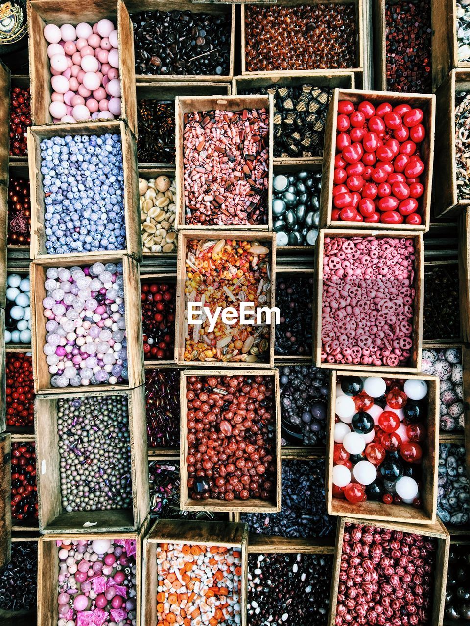 High angle view of colorful pearls in boxes at market for sale