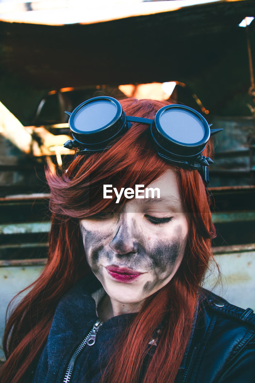 Woman looking down with charcoal stain on face