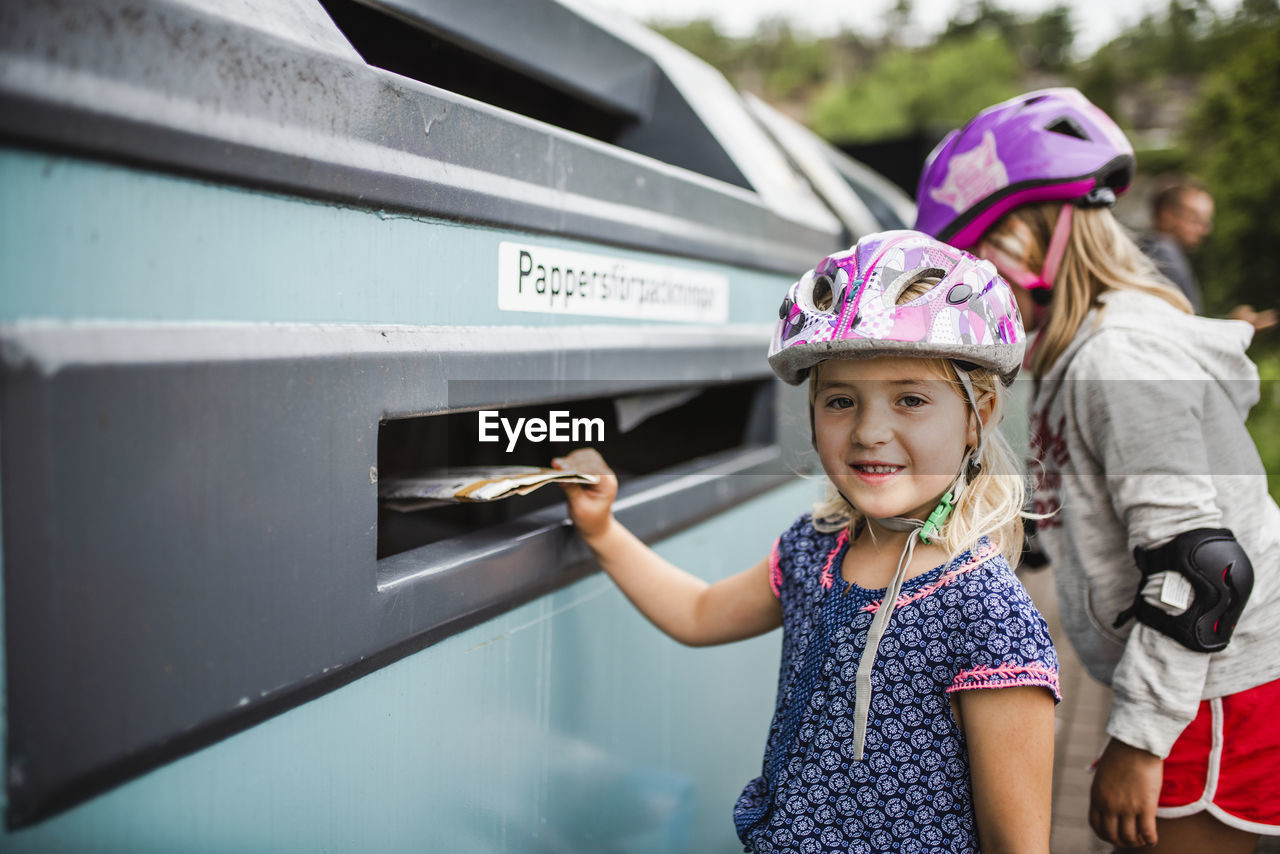 Girl putting rubbish into recycling bin