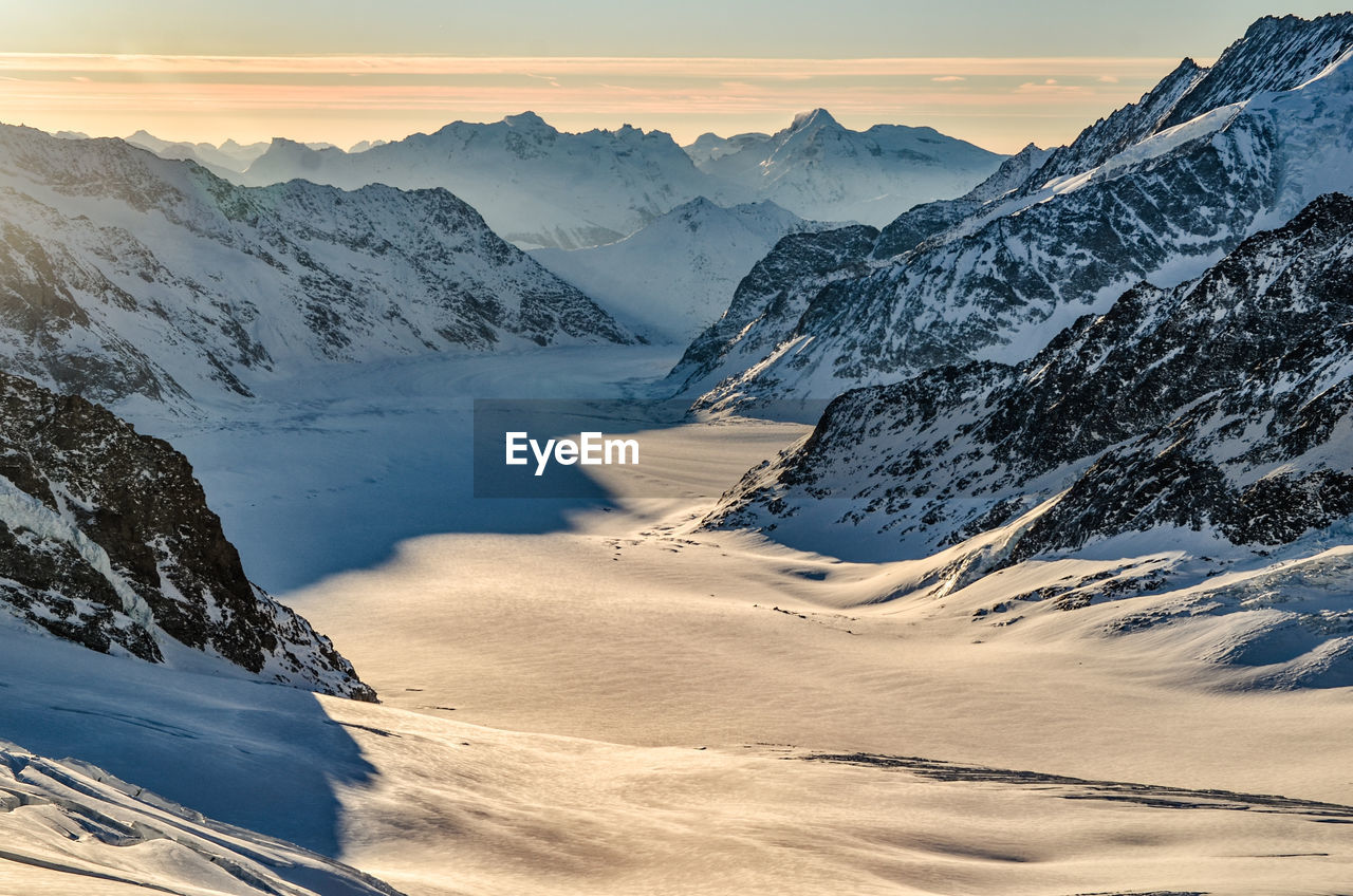 Scenic view of snowcapped mountains against sky during sunset