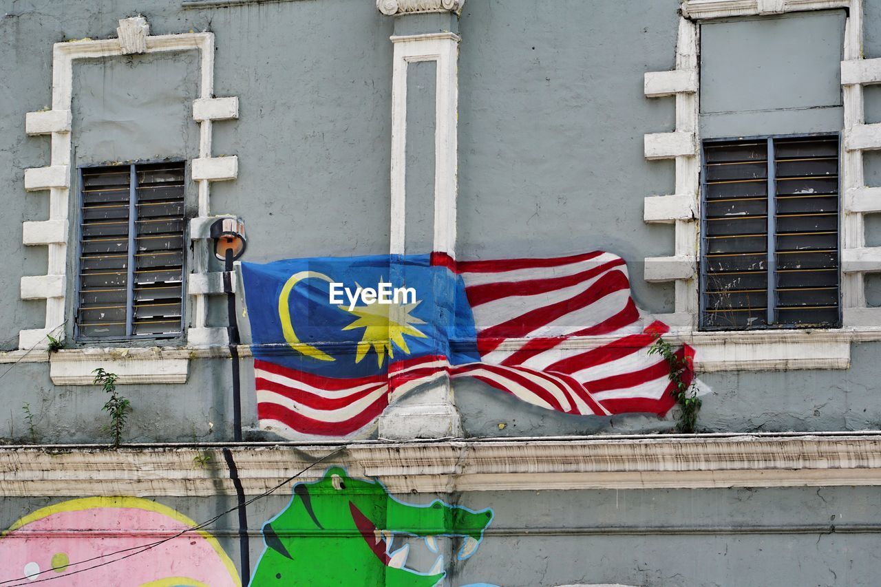 MULTI COLORED FLAGS ON BUILDING WALL