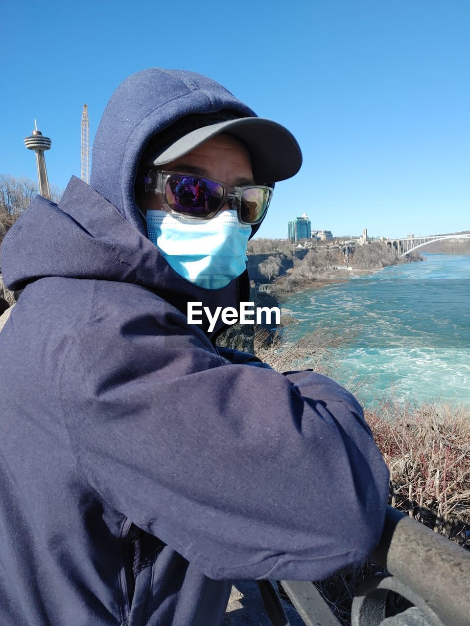 PORTRAIT OF MAN WEARING SUNGLASSES AGAINST SKY