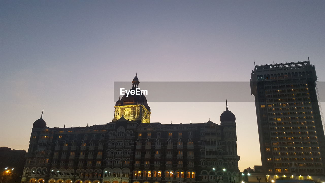 Low angle view of illuminated buildings against clear sky