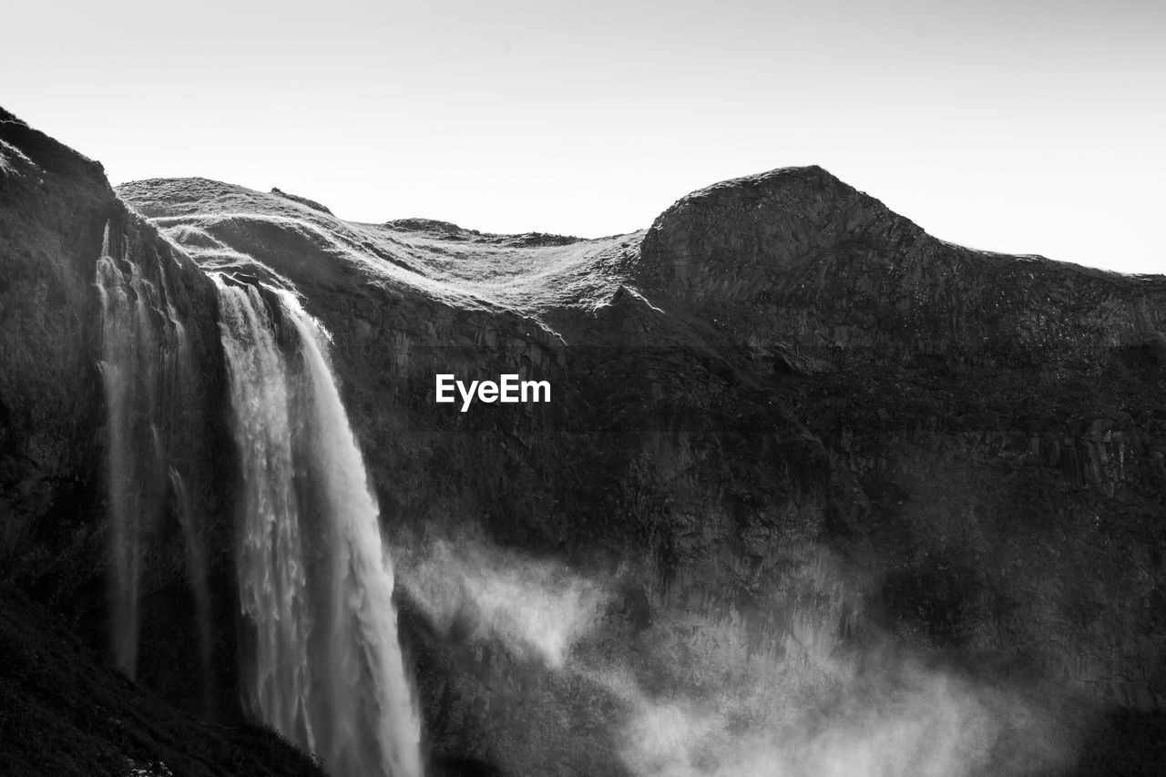 PANORAMIC VIEW OF WATERFALL AGAINST SKY