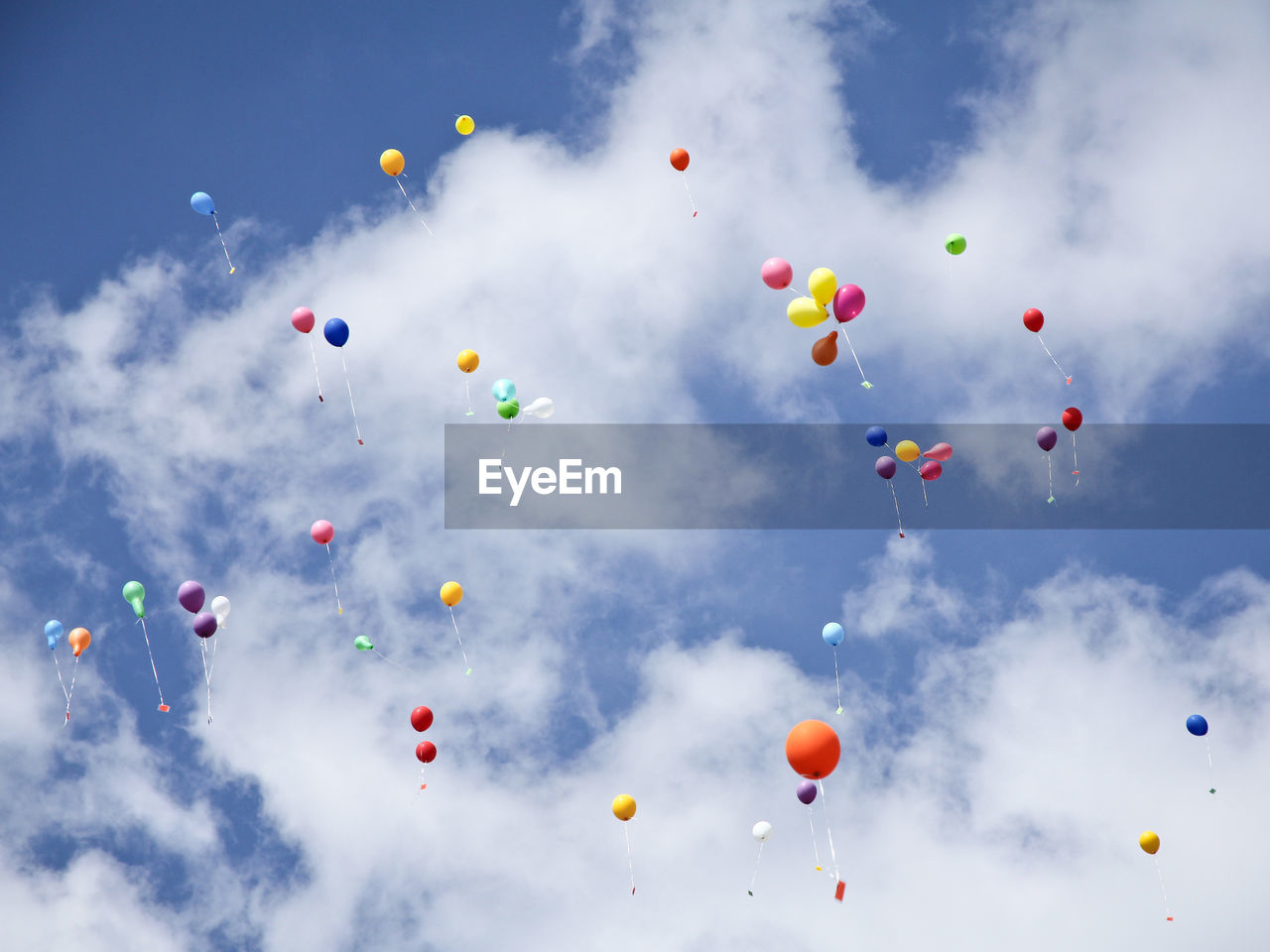 Low angle view of balloons flying against sky