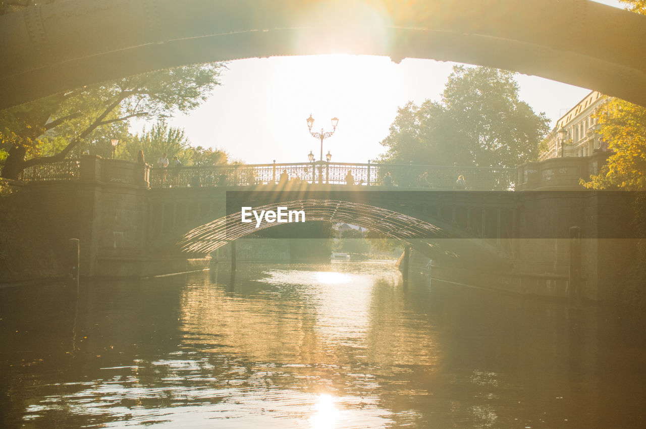 BRIDGE OVER RIVER WITH BUILDINGS IN BACKGROUND