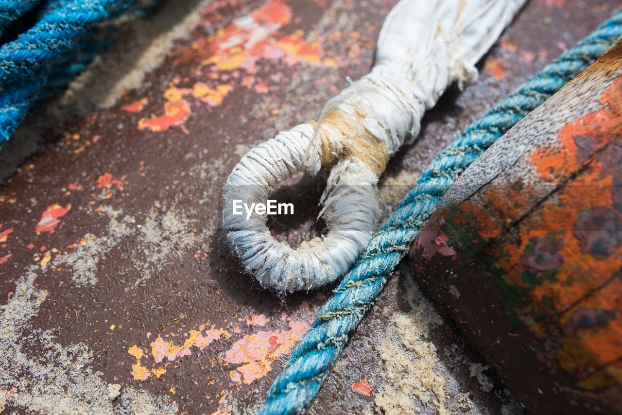 HIGH ANGLE VIEW OF ROPE ON WOOD