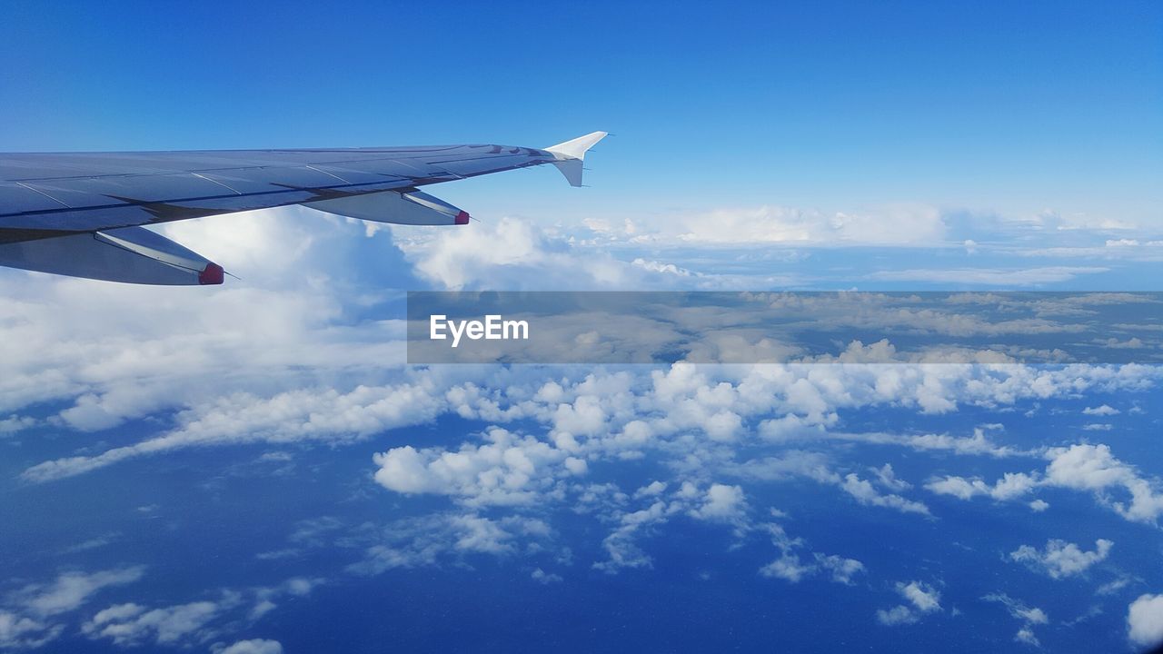 Cropped image of airplane flying against sky